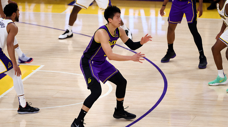 NBA季前赛现场，洛杉矶湖人队球员在球场上进行比赛对抗