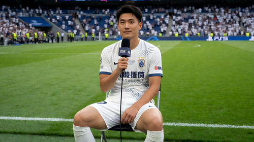一名职业足球中场球员在欧冠小组赛获胜后，于球场上接受赛后采访